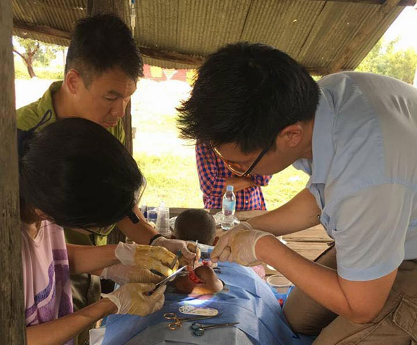 Doctors performing surgery on a underprivileged young boy in Cambodia