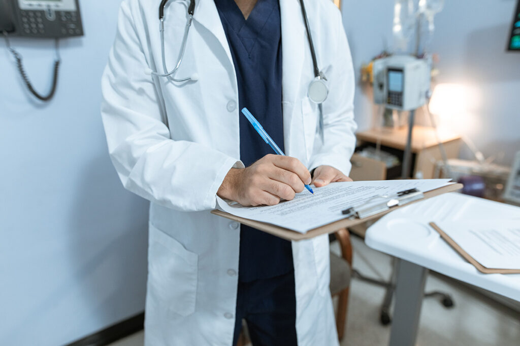 A doctor writing notes on a clipboard